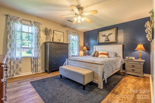 302 Redwood Pl, Lenoir, NC 28645 - bedroom with wood finished floors, multiple windows, a textured ceiling, and ceiling fan