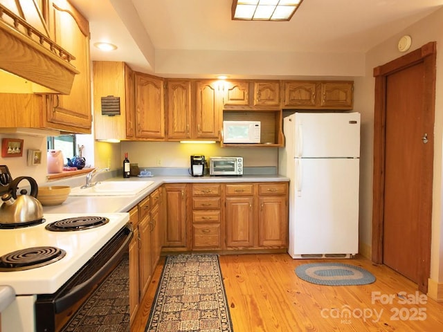 1090 Woolyshot Branch Rd, Hot Springs, NC 28743 - kitchen featuring white appliances, light countertops, brown cabinetry, and light wood-type flooring
