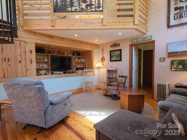1090 Woolyshot Branch Rd, Hot Springs, NC 28743 - living area featuring a high ceiling, radiator heating unit, wood finished floors, and recessed lighting