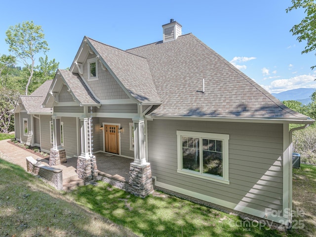 62 Sharp Rd W, Black Mountain, NC 28711 - view of side of home featuring a chimney, roof with shingles, covered porch, and a lawn