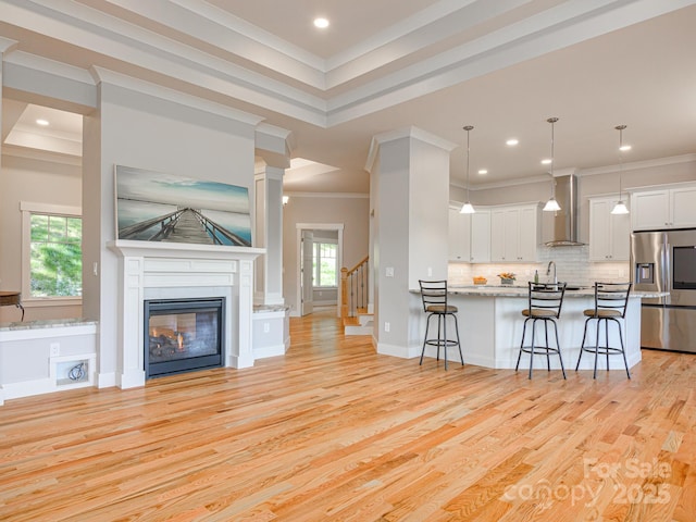 62 Sharp Rd W, Black Mountain, NC 28711 - kitchen with stainless steel fridge, wall chimney exhaust hood, a kitchen breakfast bar, ornamental molding, and open floor plan