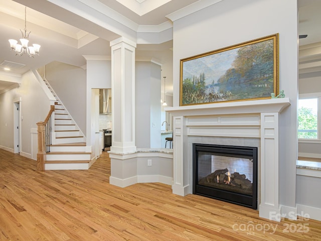 62 Sharp Rd W, Black Mountain, NC 28711 - unfurnished living room with light wood-style floors, ornate columns, stairs, a multi sided fireplace, and crown molding