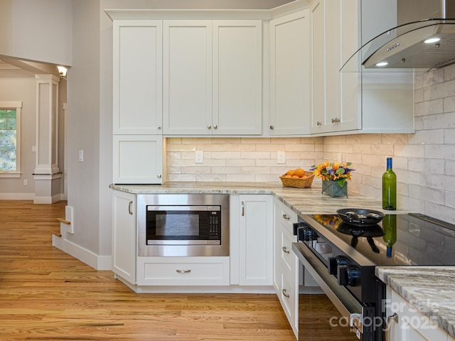 62 Sharp Rd W, Black Mountain, NC 28711 - kitchen featuring stainless steel appliances, exhaust hood, tasteful backsplash, light wood-type flooring, and light stone countertops