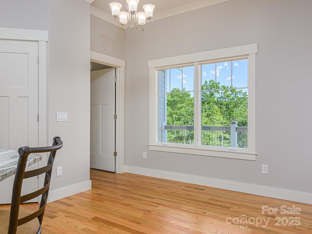 62 Sharp Rd W, Black Mountain, NC 28711 - unfurnished dining area with light wood finished floors, a chandelier, and ornamental molding