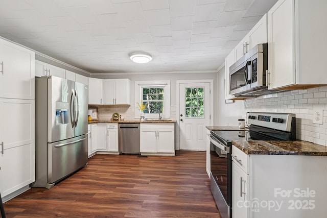 911 Elm St, Kannapolis, NC 28081 - kitchen featuring stainless steel appliances, decorative backsplash, dark wood-type flooring, white cabinetry, and ornamental molding