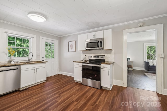 911 Elm St, Kannapolis, NC 28081 - kitchen featuring stainless steel appliances, ornamental molding, dark stone counters, dark wood-type flooring, and white cabinetry