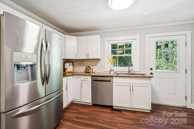 911 Elm St, Kannapolis, NC 28081 - kitchen with appliances with stainless steel finishes, crown molding, dark stone counters, dark wood finished floors, and backsplash