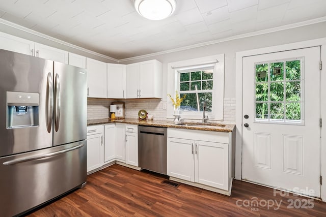 911 Elm St, Kannapolis, NC 28081 - kitchen with appliances with stainless steel finishes, crown molding, decorative backsplash, light stone countertops, and dark wood-style flooring