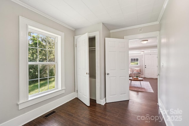 911 Elm St, Kannapolis, NC 28081 - unfurnished bedroom with multiple windows, ornamental molding, dark wood-style floors, and a closet