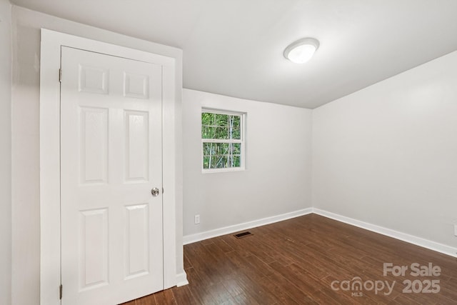 911 Elm St, Kannapolis, NC 28081 - unfurnished bedroom with baseboards and dark wood-style floors