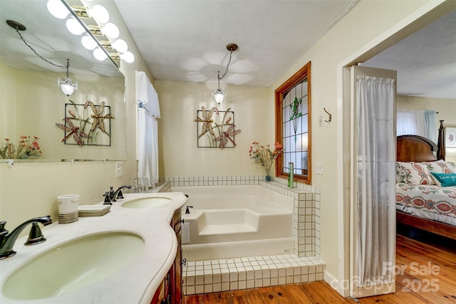 1504 Red Marble Rd, Andrews, NC 28901 - bathroom featuring ensuite bathroom, wood finished floors, a garden tub, double vanity, and a textured ceiling