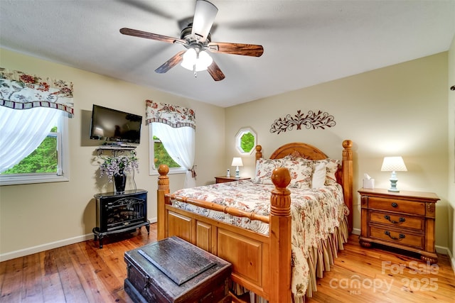 1504 Red Marble Rd, Andrews, NC 28901 - bedroom with a wood stove, light wood-style floors, and ceiling fan