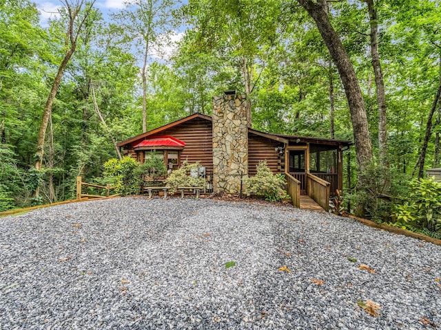 116 Chalet Rd, Lake Lure, NC 28746 - view of front of house featuring a chimney, driveway, and log siding