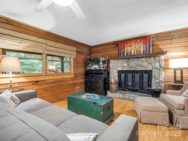 116 Chalet Rd, Lake Lure, NC 28746 - living area featuring wooden walls, wood finished floors, a fireplace, and ceiling fan