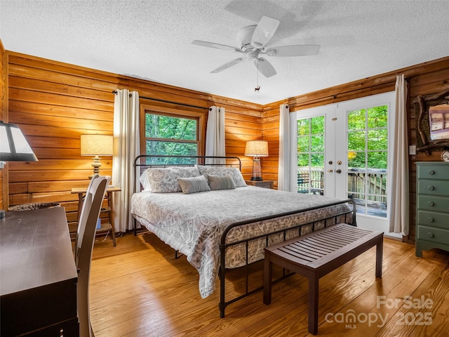 116 Chalet Rd, Lake Lure, NC 28746 - bedroom featuring light wood finished floors, a textured ceiling, access to outside, multiple windows, and french doors