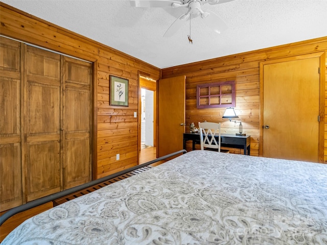 116 Chalet Rd, Lake Lure, NC 28746 - bedroom featuring a textured ceiling, wood walls, and a ceiling fan