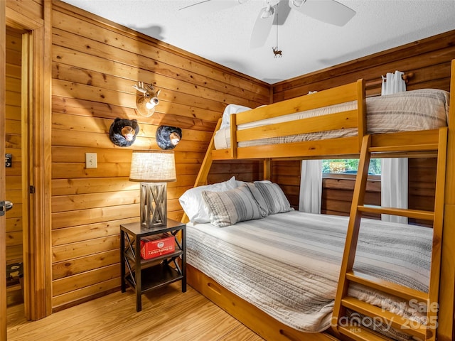 116 Chalet Rd, Lake Lure, NC 28746 - bedroom featuring light wood finished floors, a textured ceiling, and wooden walls