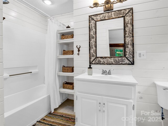 116 Chalet Rd, Lake Lure, NC 28746 - bathroom featuring wood walls, vanity, shower / bath combo with shower curtain, and a textured ceiling