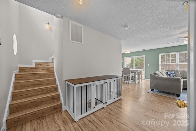 8009 Trotter Rd, Charlotte, NC 28216 - staircase featuring a textured ceiling, wood finished floors, and ceiling fan
