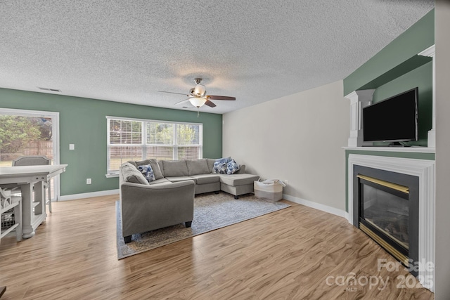 8009 Trotter Rd, Charlotte, NC 28216 - living room featuring a ceiling fan, wood finished floors, plenty of natural light, and a textured ceiling