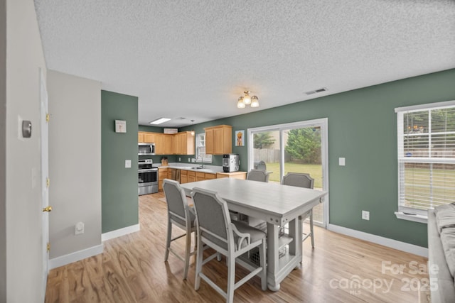 8009 Trotter Rd, Charlotte, NC 28216 - dining area with a textured ceiling, plenty of natural light, and light wood-type flooring