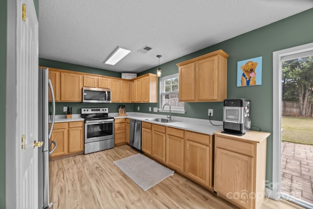 8009 Trotter Rd, Charlotte, NC 28216 - kitchen featuring appliances with stainless steel finishes, healthy amount of natural light, light countertops, light wood-style floors, and a textured ceiling