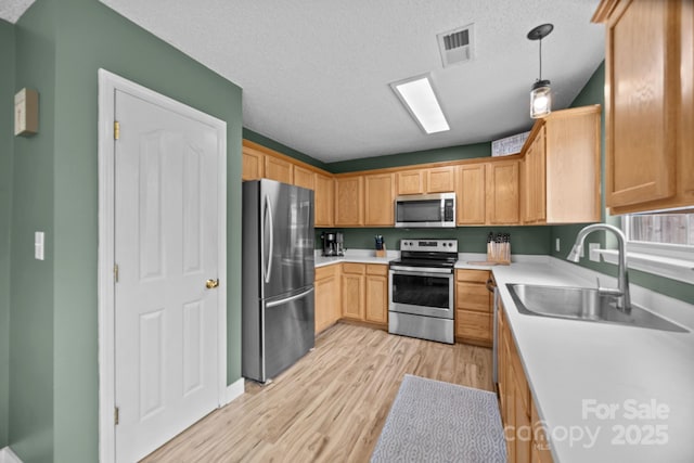 8009 Trotter Rd, Charlotte, NC 28216 - kitchen with stainless steel appliances, light wood finished floors, light countertops, pendant lighting, and a textured ceiling