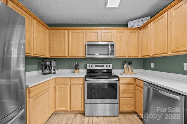 8009 Trotter Rd, Charlotte, NC 28216 - kitchen with appliances with stainless steel finishes, light wood-style floors, light countertops, and a textured ceiling