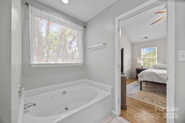 8009 Trotter Rd, Charlotte, NC 28216 - ensuite bathroom featuring a bath, a textured ceiling, and ceiling fan