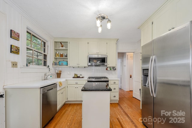 57 Patton Ct SE, Concord, NC 28025 - kitchen with stainless steel appliances, a kitchen island, decorative backsplash, light wood finished floors, and crown molding