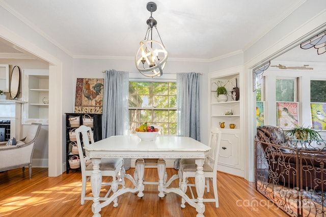 57 Patton Ct SE, Concord, NC 28025 - dining space with a chandelier, light wood-style floors, ornamental molding, and built in shelves