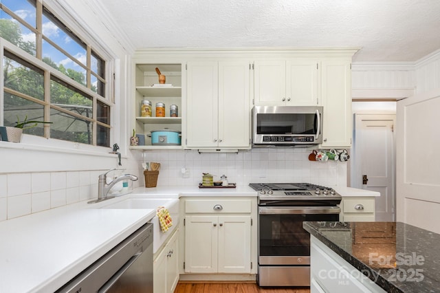 57 Patton Ct SE, Concord, NC 28025 - kitchen with stainless steel appliances, a textured ceiling, tasteful backsplash, ornamental molding, and white cabinetry