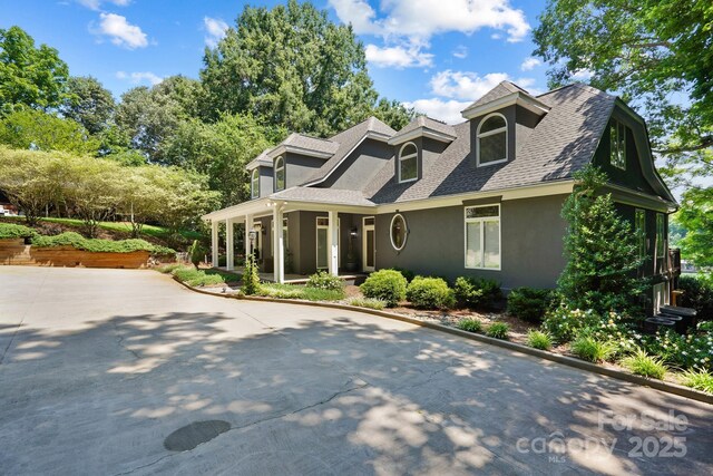7040 Hyde St, Sherrills Ford, NC 28673 - cape cod house featuring stucco siding, a shingled roof, covered porch, and concrete driveway