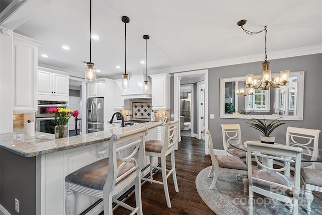 835 Misty Arbor Frd Unit 76, Clover, SC 29710 - kitchen featuring stainless steel appliances, decorative backsplash, a chandelier, premium range hood, and dark wood finished floors