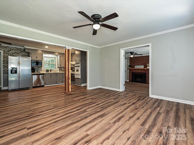 159 Valleydale Dr, Gastonia, NC 28056 - unfurnished living room featuring ceiling fan, crown molding, a brick fireplace, and dark wood finished floors