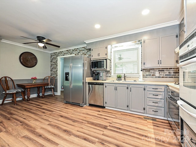 159 Valleydale Dr, Gastonia, NC 28056 - kitchen with appliances with stainless steel finishes, crown molding, a ceiling fan, light countertops, and light wood-style flooring