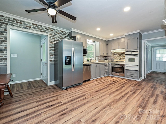 159 Valleydale Dr, Gastonia, NC 28056 - kitchen with appliances with stainless steel finishes, gray cabinetry, a warming drawer, ornamental molding, and wood finished floors