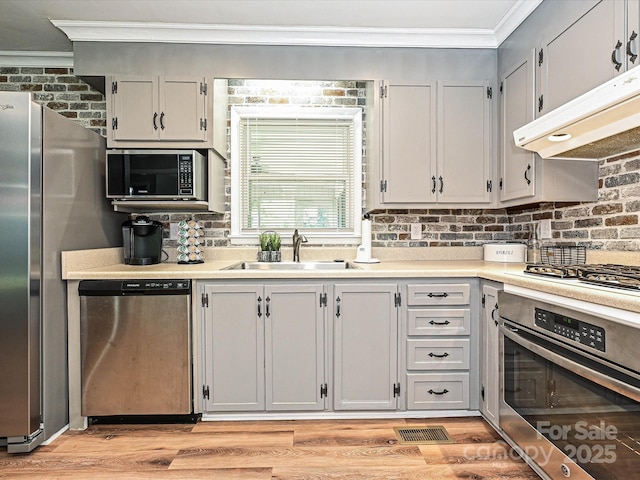 159 Valleydale Dr, Gastonia, NC 28056 - kitchen with stainless steel appliances, ornamental molding, under cabinet range hood, light countertops, and light wood-style floors