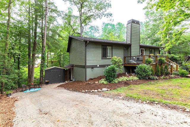 14 New Bern Dr, Fletcher, NC 28732 - view of home's exterior with a storage unit, a chimney, a wooden deck, and dirt driveway