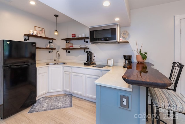 14 New Bern Dr, Fletcher, NC 28732 - kitchen featuring freestanding refrigerator, stainless steel microwave, a peninsula, a kitchen breakfast bar, and white cabinets