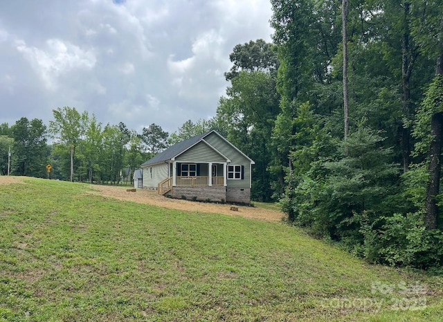 32967 Poplar Lane Rd, Albemarle, NC 28001 - view of front facade with crawl space, covered porch, a front yard, and a forest view