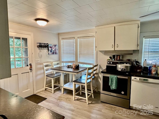 39 Hemphill Rd, Waynesville, NC 28785 - kitchen featuring white dishwasher, stainless steel electric range, dark countertops, white cabinets, and light wood finished floors