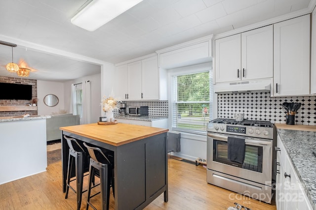 700 Perkins St, Lowell, NC 28098 - kitchen featuring stainless steel appliances, under cabinet range hood, wooden counters, and white cabinets