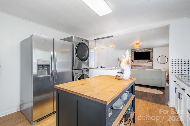 700 Perkins St, Lowell, NC 28098 - kitchen featuring stacked washer / drying machine, stainless steel fridge with ice dispenser, butcher block countertops, white cabinetry, and light wood-style flooring
