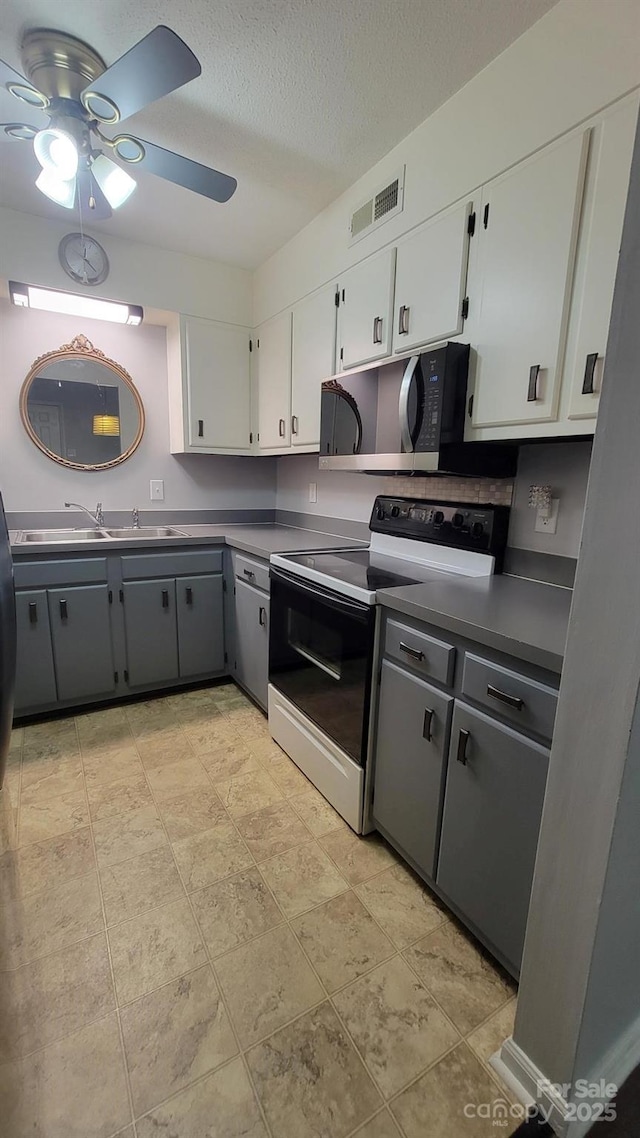 2116 S Main St, Kannapolis, NC 28081 - kitchen with black appliances, gray cabinetry, ceiling fan, white cabinets, and a textured ceiling