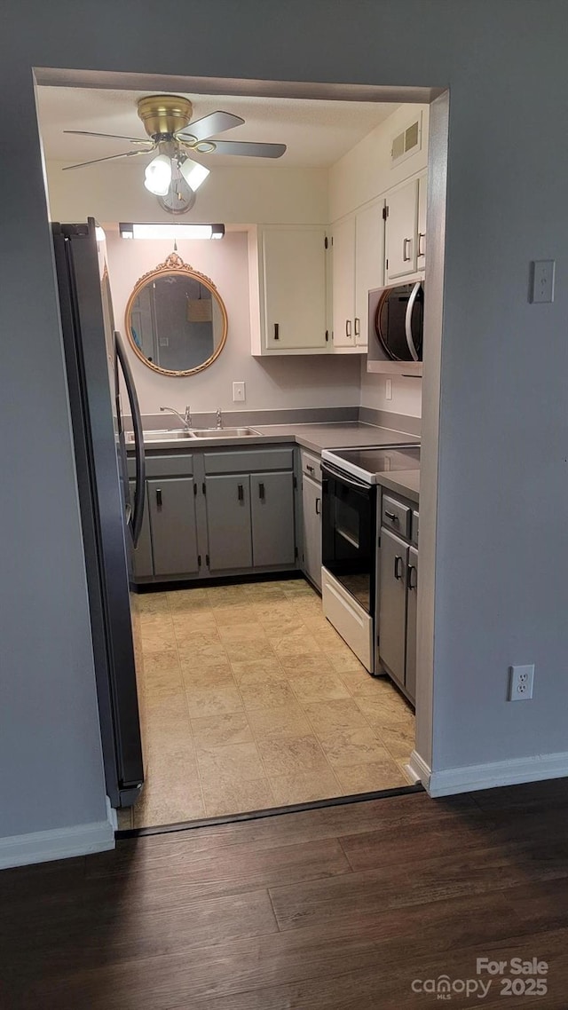 2116 S Main St, Kannapolis, NC 28081 - kitchen featuring appliances with stainless steel finishes, a ceiling fan, white cabinetry, and light wood-type flooring