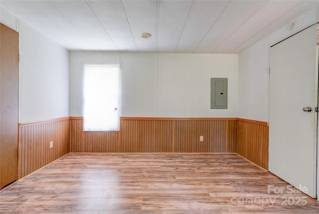121 Whipporwill Ct, Grover, NC 28073 - unfurnished room featuring electric panel, wood finished floors, a wainscoted wall, wood walls, and a smoke detector