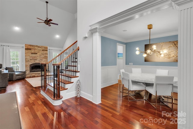 4552 Sawgrass Ct, Denver, NC 28037 - dining area featuring ceiling fan, a fireplace, stairway, dark wood-type flooring, and a wainscoted wall