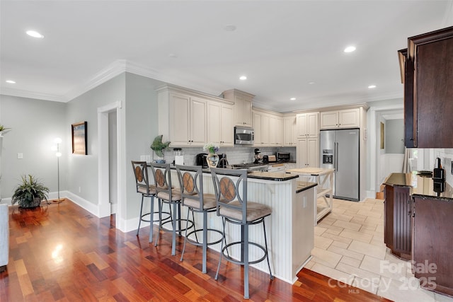 4552 Sawgrass Ct, Denver, NC 28037 - kitchen with stainless steel appliances, a peninsula, tasteful backsplash, a breakfast bar area, and dark countertops