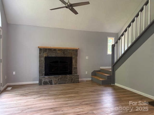 39 Moondust Dr, Waynesville, NC 28786 - unfurnished living room featuring lofted ceiling, stairs, light wood-style floors, a ceiling fan, and a textured ceiling